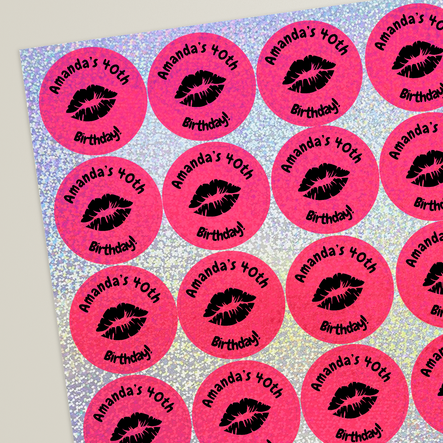 Sheet of circular pink holographic stickers. The stickers include placeholder text reading 'Amanda's 40th' at the top and 'Birthday' bottom, around a set of lips icon, indicating customisable design options and colour choices.