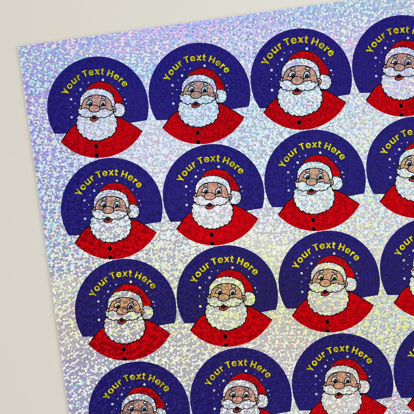 Sheet of round blue holographic stickers featuring Father Christmas with a snowy backdrop. Each sticker has placeholder text reading 'Your text here' curved above the illustration for customisation.