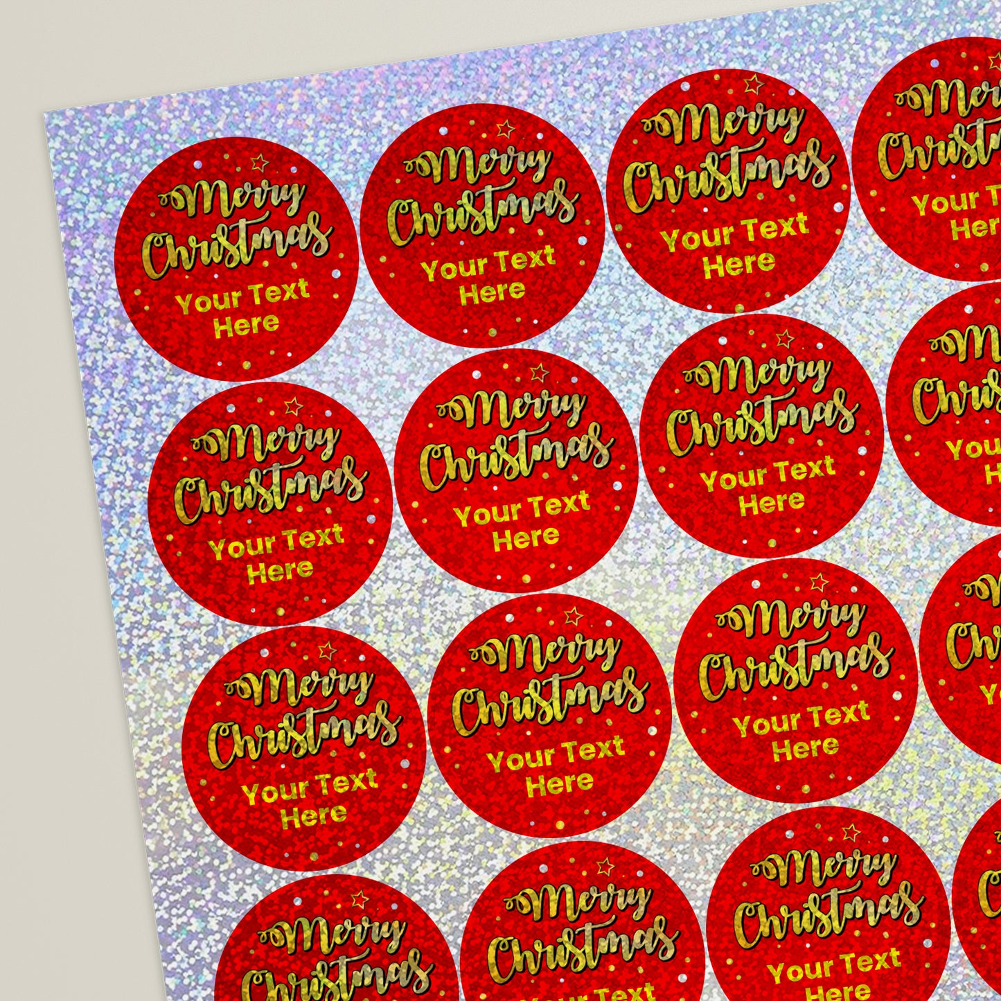 A sheet of customisable circular stickers featuring a holographic red background with 'Merry Christmas' in gold script font below which placeholder text 'Your Text Here'.