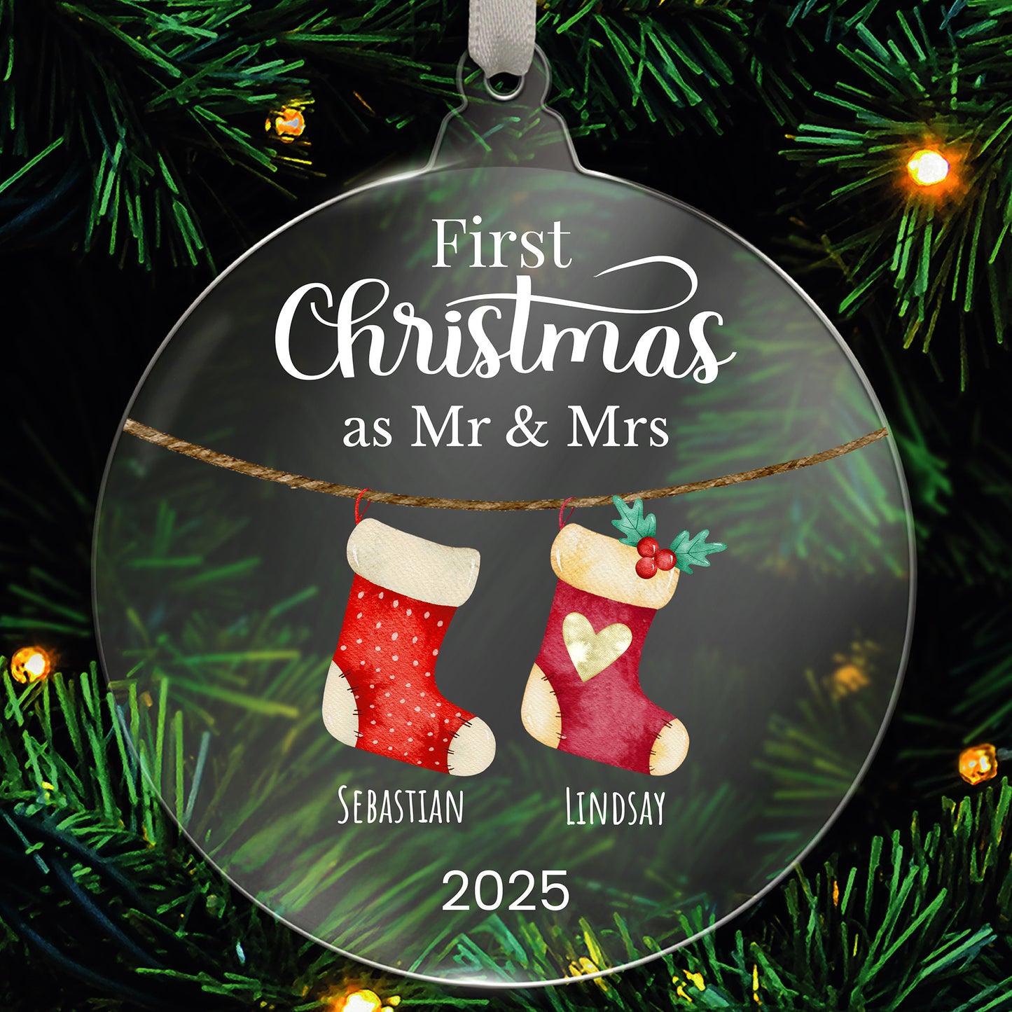 Decorative personalised Christmas ornament with stockings and text 'First Christmas as Mr & Mrs' on a green tree background.