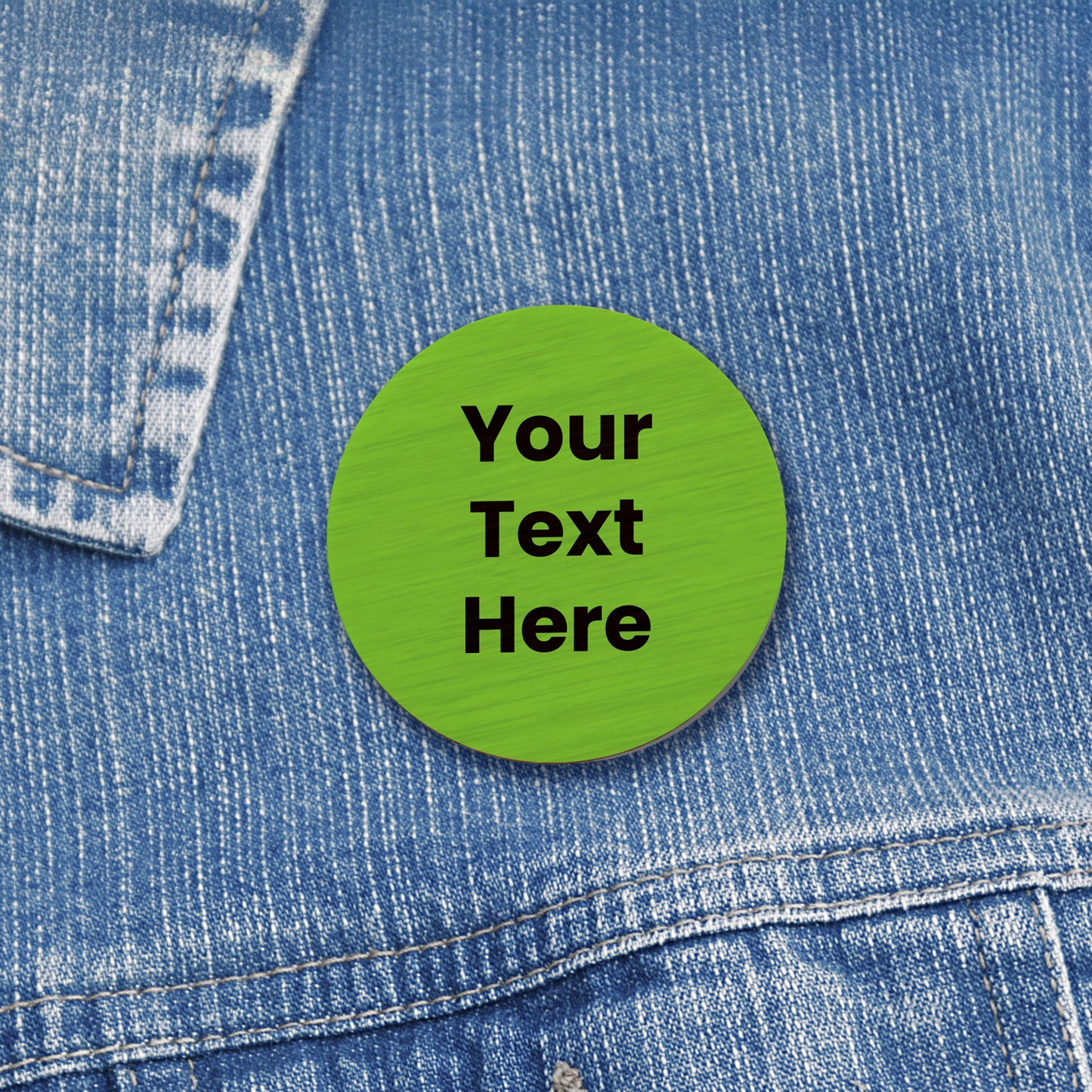 A 38mm circular badge crafted from natural bamboo and coloured green, featuring the placeholder text 'Your text Here' in black capital letters on the front, worn on a denim jacket