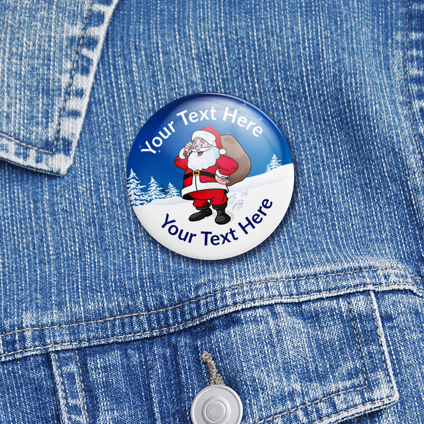 38mm round personalised badges featuring a cheerful Father Christmas holding a sack of presents set against a snowy blue background with pine trees; includes customisable text above and below Santa, equipped with safety pin fastenings—ideal for festive rewards. Worn on denim jacket