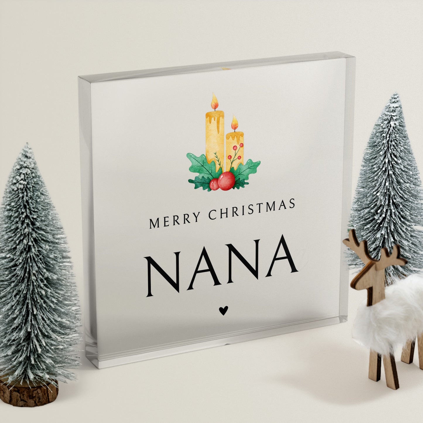 Christmas clear acrylic block with 'Merry Christmas Nana' text, below 2 lit candles with holly.