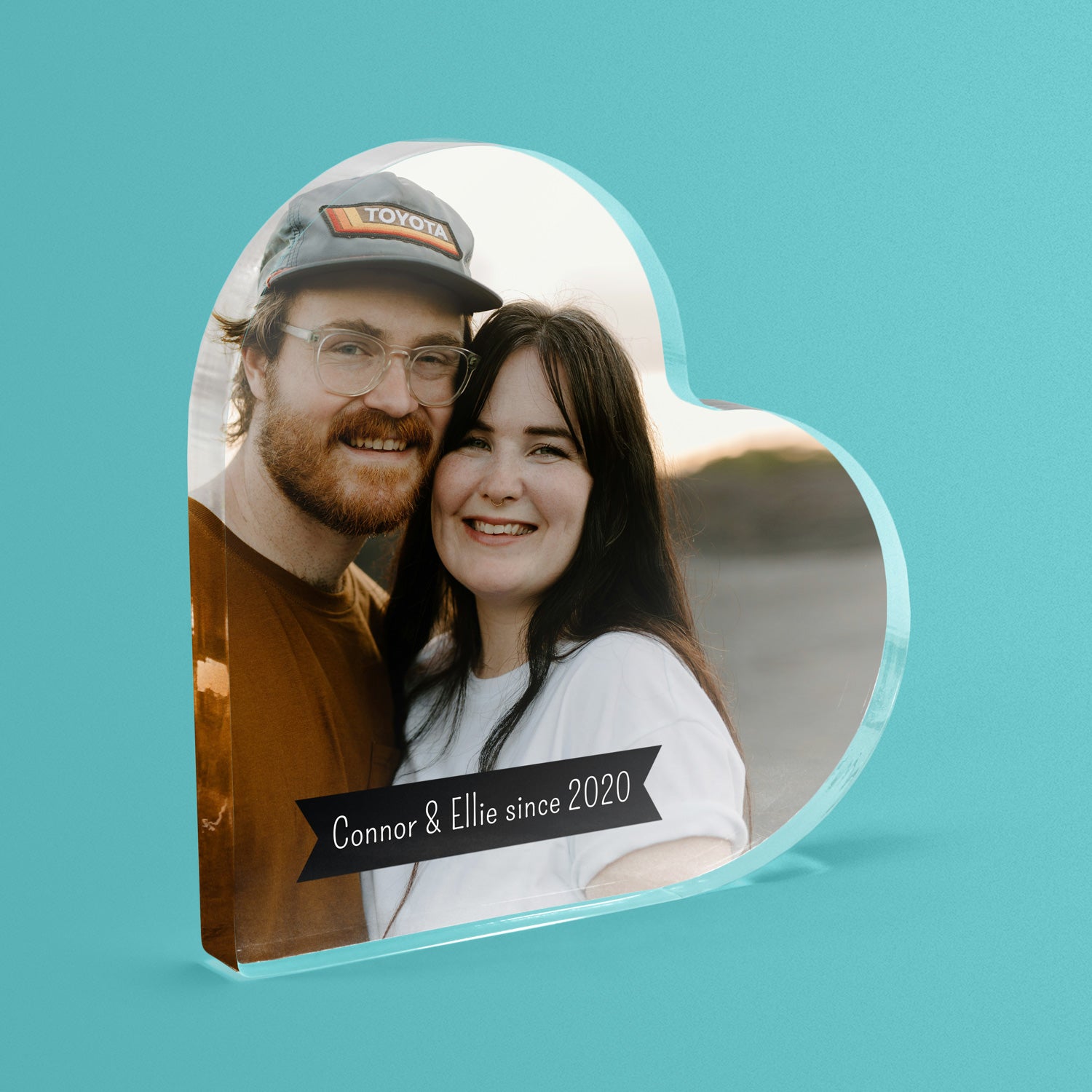 Heart-shaped photo block with a couple's picture and 'Connor & Ellie since 2020' text on a teal background.