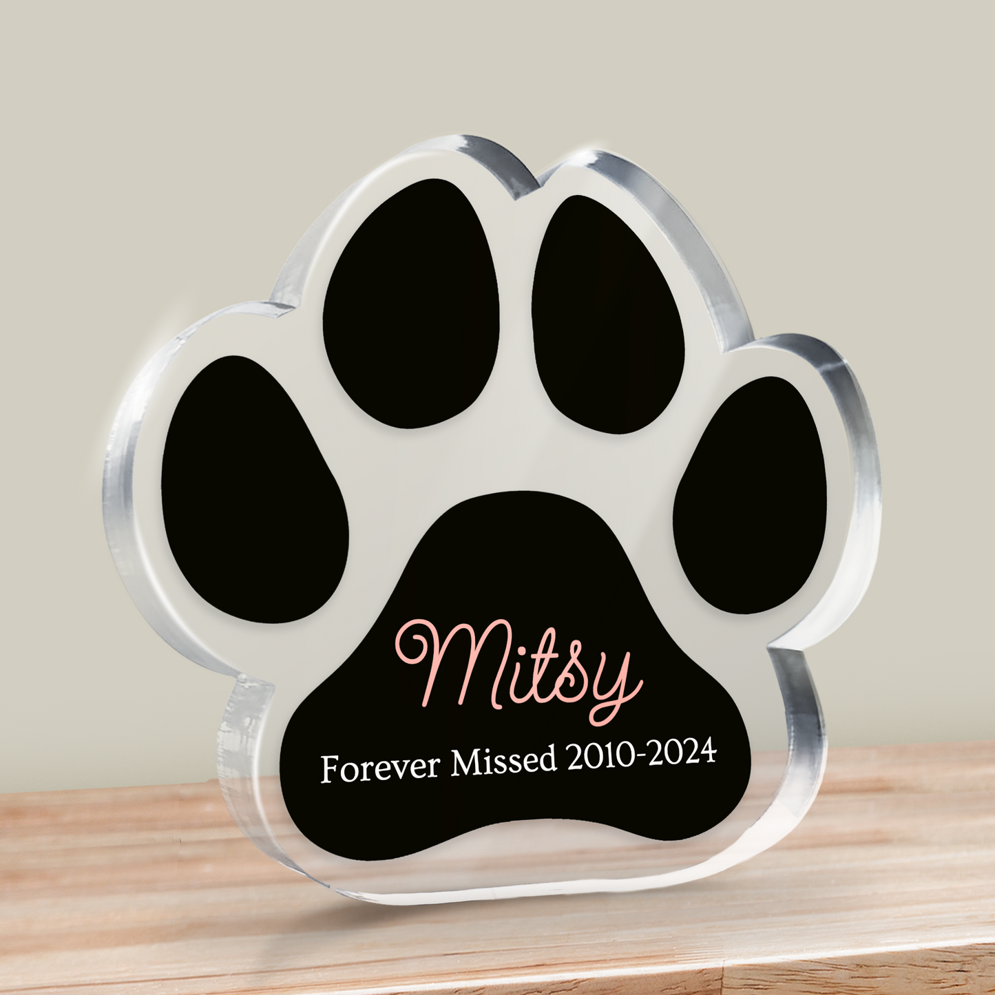 Paw-shaped memorial Block with 'Mitsy Forever Missed 2010-2024' on a wooden surface.