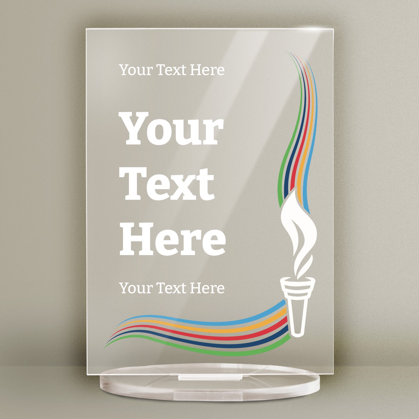 A translucent acrylic award plaque with placeholder text reading 'Your Text Here' and 'YOUR TEXT HERE' in bold white letters. A stylised white torch with colourful flames in blue, green, orange, and red appears on the right side. A matching wavy ribbon design runs across the bottom. The award stands upright on a clear acrylic base.