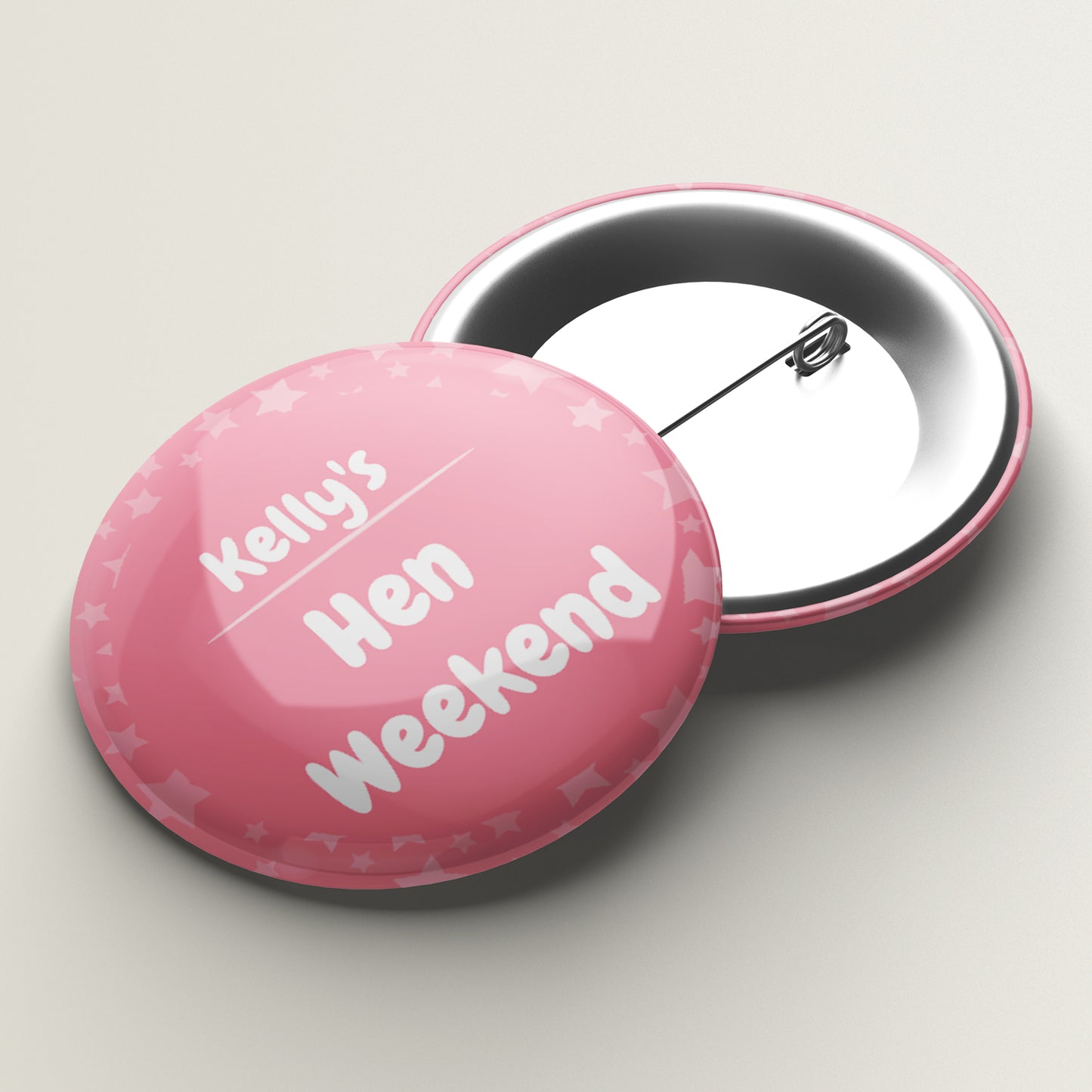 A set of two personalized star-shaped badges. One badge is pink with 'Kelly's Hen Weekend' written on it, and the other is white with 'Stag Weekend' written on it.
