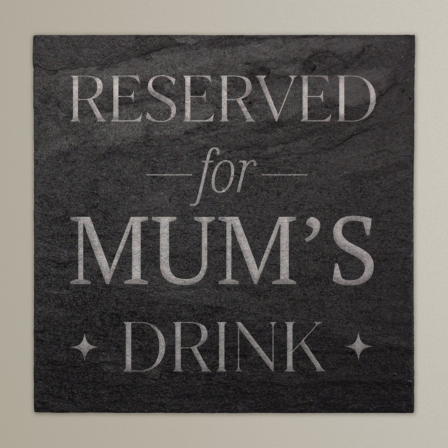 A square slate coaster with the text 'RESERVED for MUM'S DRINK' printed in the centre.