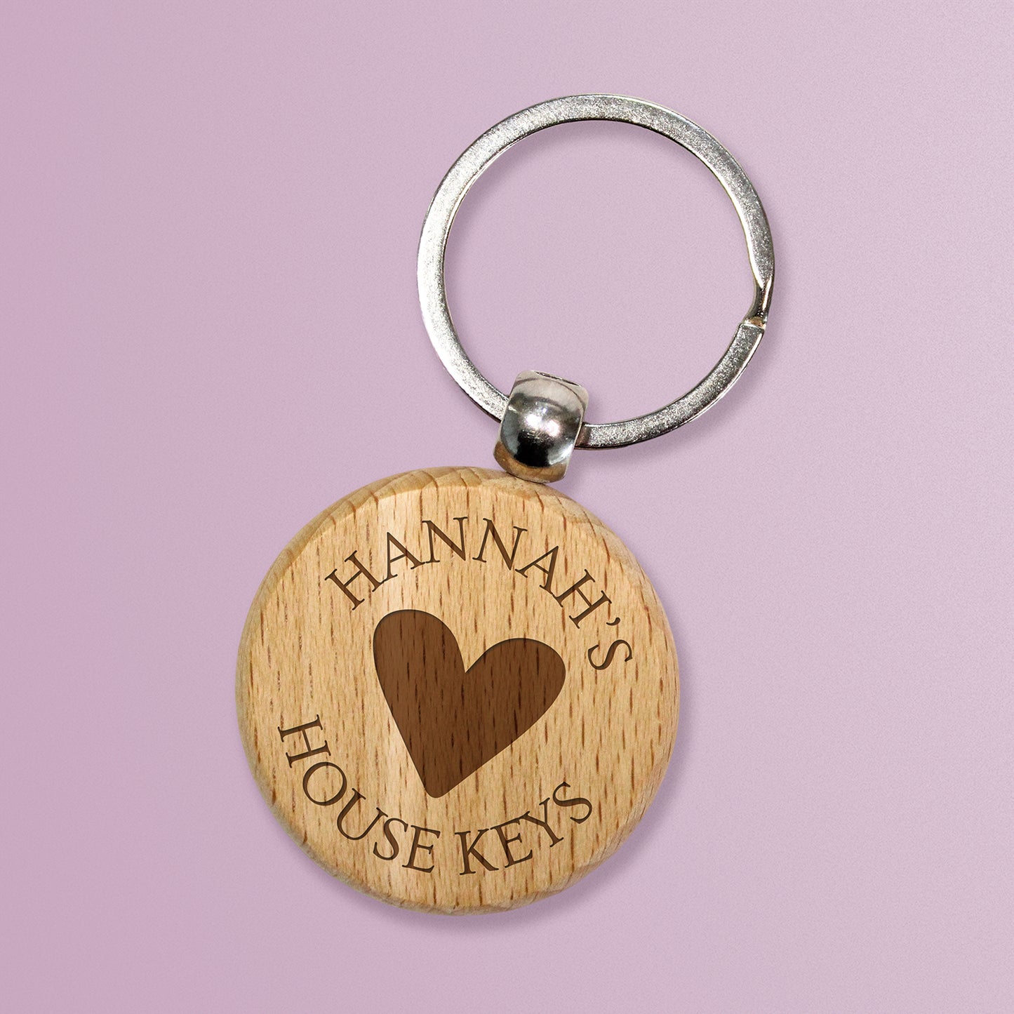 A wooden keyring with a stainless steel keychain, featuring an etched image of a heart surrounded by the text 'Hannah's House Keys'