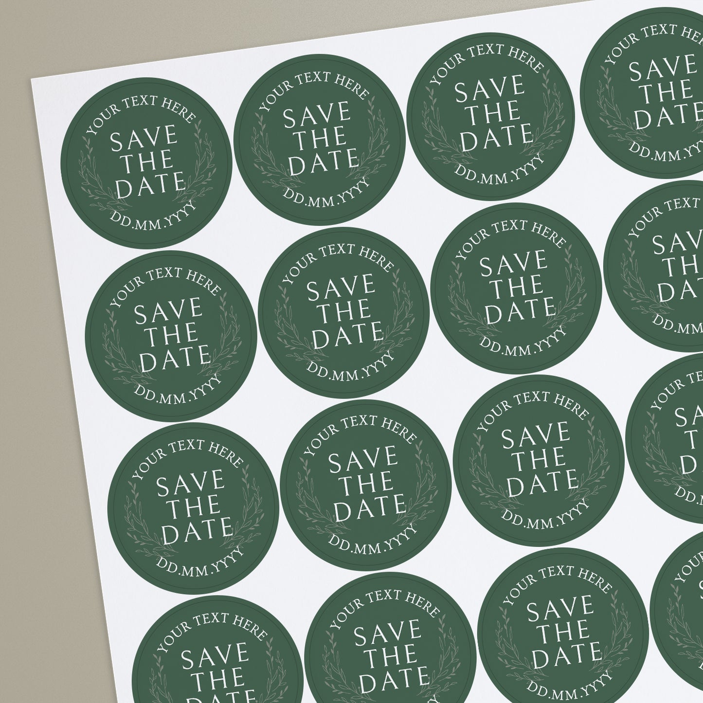 A sheet of round green personalised save the date sticker with text and a leaf pattern.
