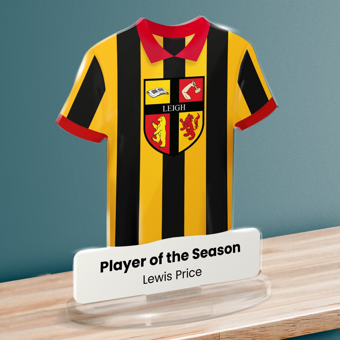 Acrylic t-shirt plaque showing black and gold striped sports shirt with a red collar featuring 'Leigh' emblem and 'Player of the Season' text below.