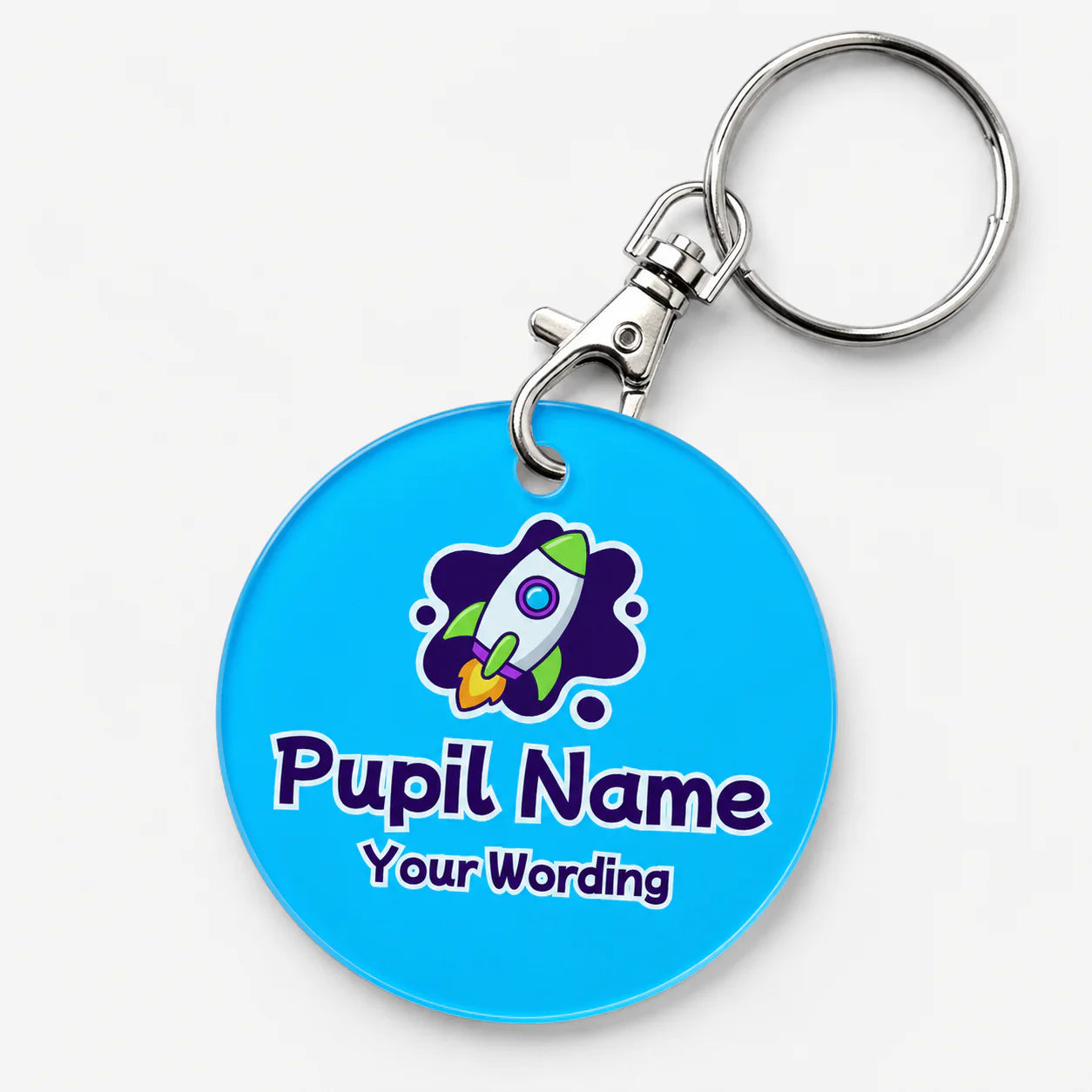 A custom acrylic keychain with a bright blue face, featuring a cartoon rocket graphic and the customisable text 'Pupil Name' and 'Your Wording'.