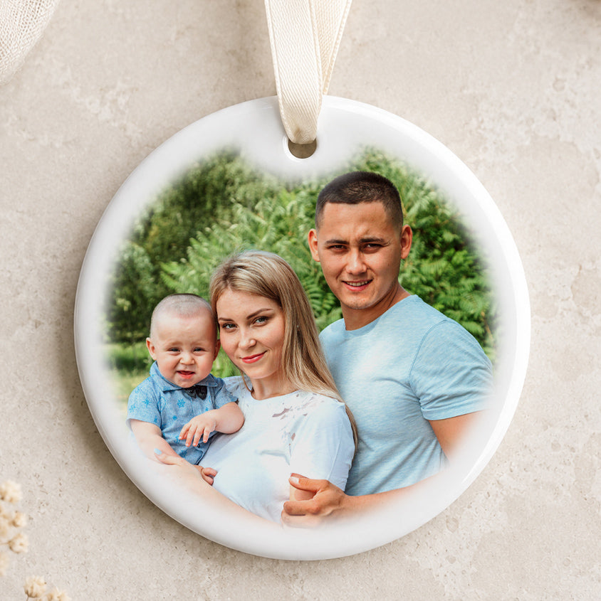 Personalised circular ceramic Christmas bauble featuring an uploaded photo and ivory hanging ribbon
