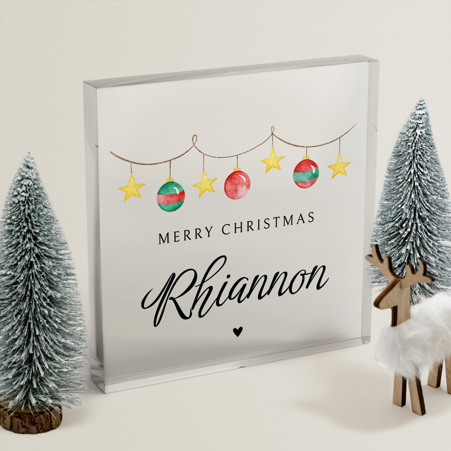Clear acrylic block with Christmas-themed artwork with decorative elements on a neutral background