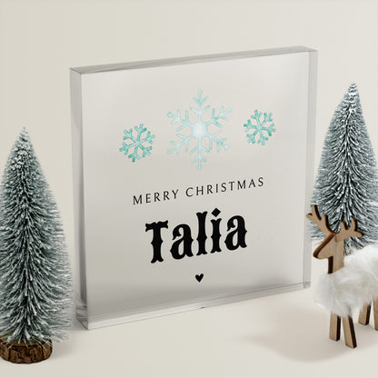 Clear acrylic block with teal snowflakes and 'Merry Christmas Talia' text, surrounded by decorative trees and a deer.