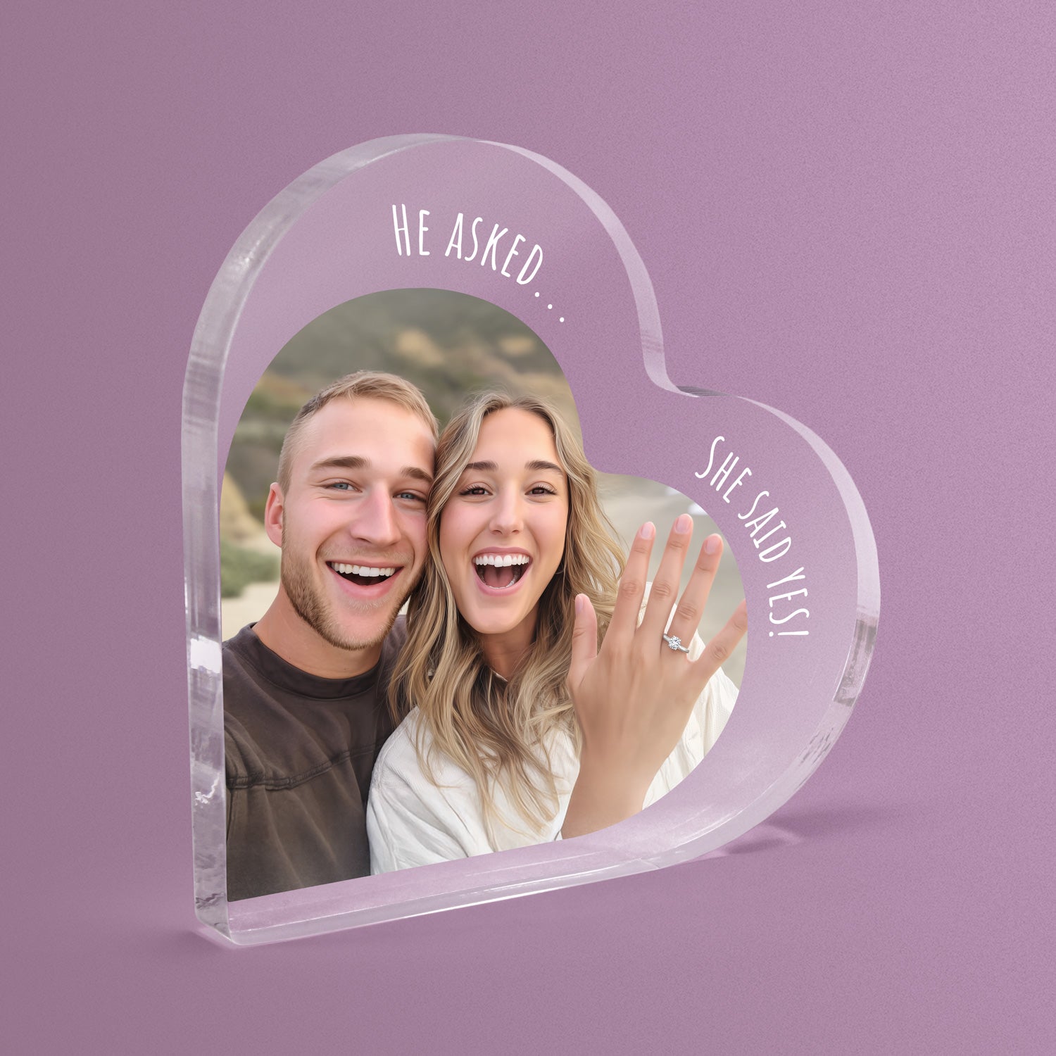 Heart-shaped acrylic photo block with a couple's picture and 'He Asked... She Said Yes!' text on a pink background.