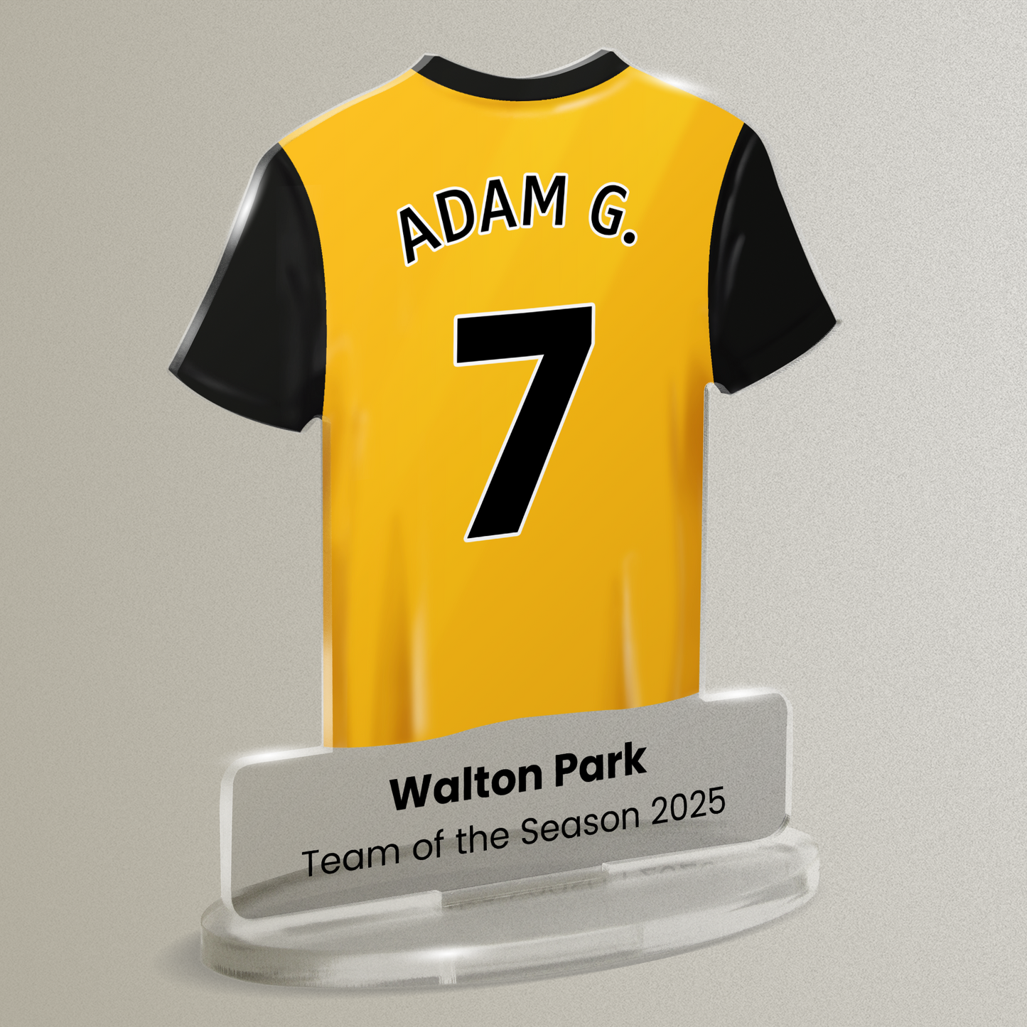 Acrylic t-shirt plaque with a yellow sports shirt design with black accents. Shirt has the wording 'Adam G' and number '7', with wording 'Walton Park' 'Team of the Season' underneath. Plaque is shown on a pale gray background.
