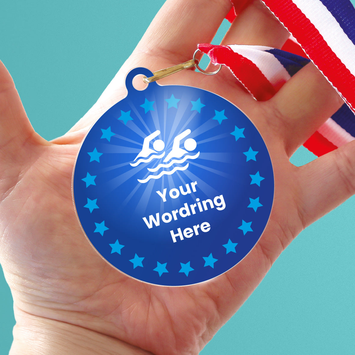 Acrylic personalised medal with stripy ribbon, in a hand, showing blue design with blue stars, swimming icon and personalised wording.