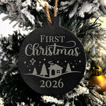 Decorative Slate Christmas ornament etched with 'First Christmas 2026' text and a winter scene, hanging on a tree.