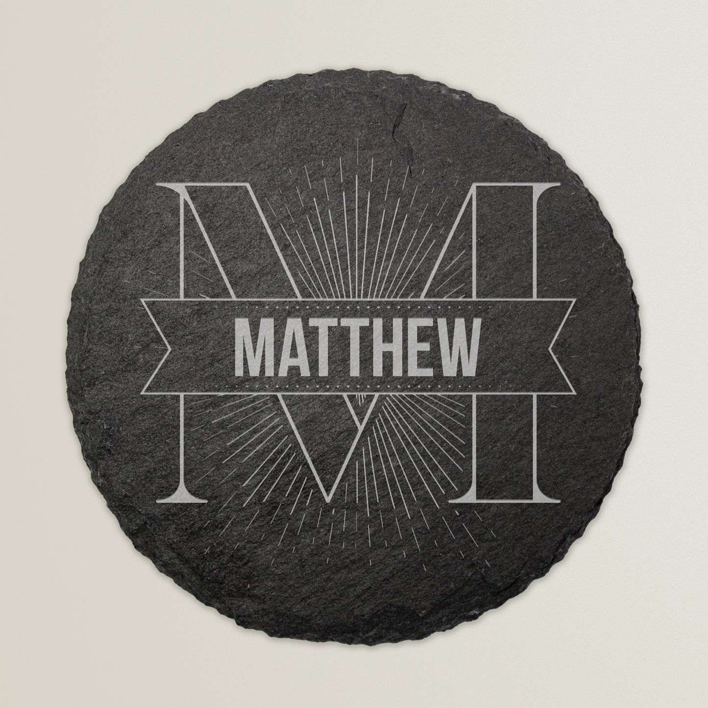 Round slate coaster with engraved name 'Matthew' on a light grey background