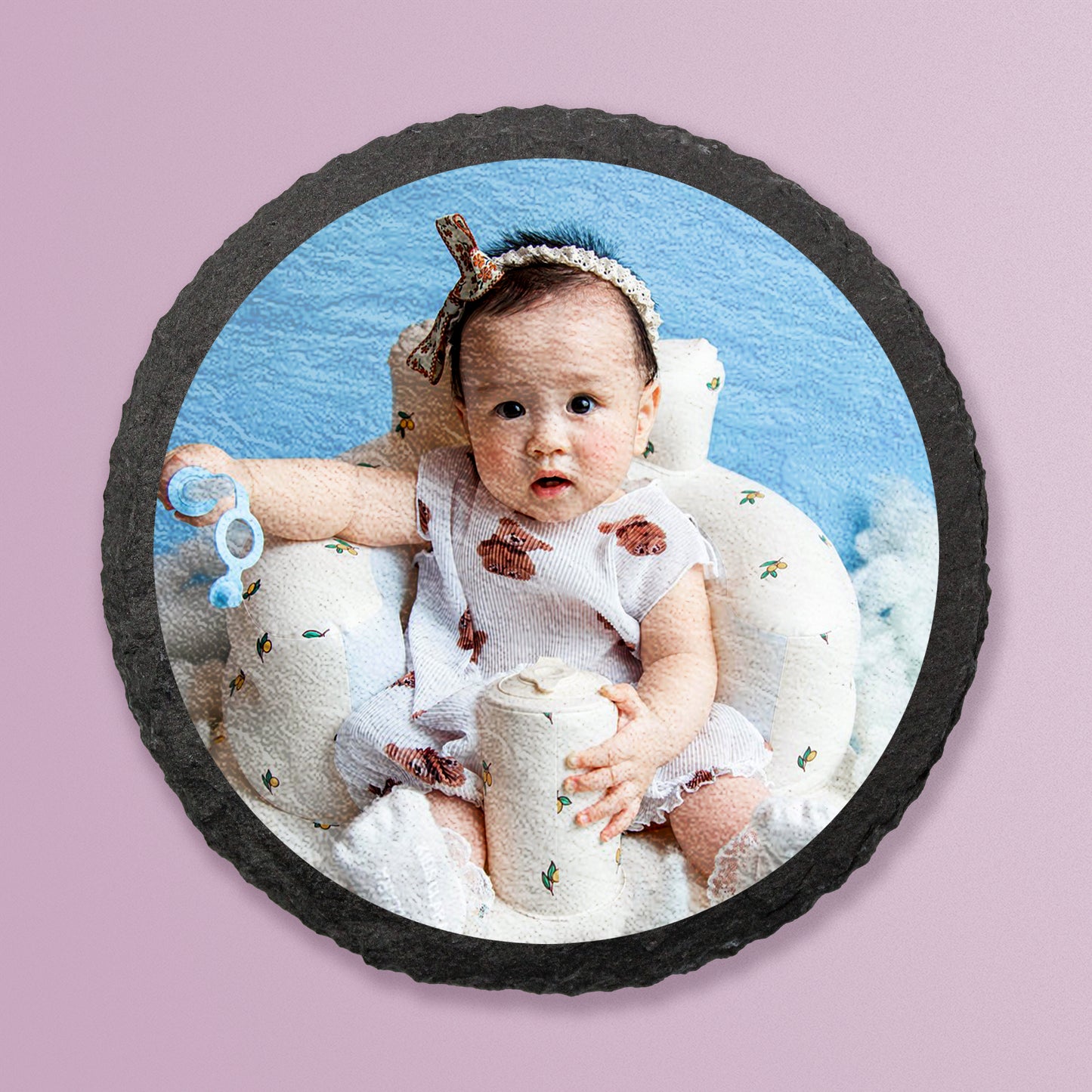 Photo of baby digitally printed onto natural circle slate coaster on a lilac background.