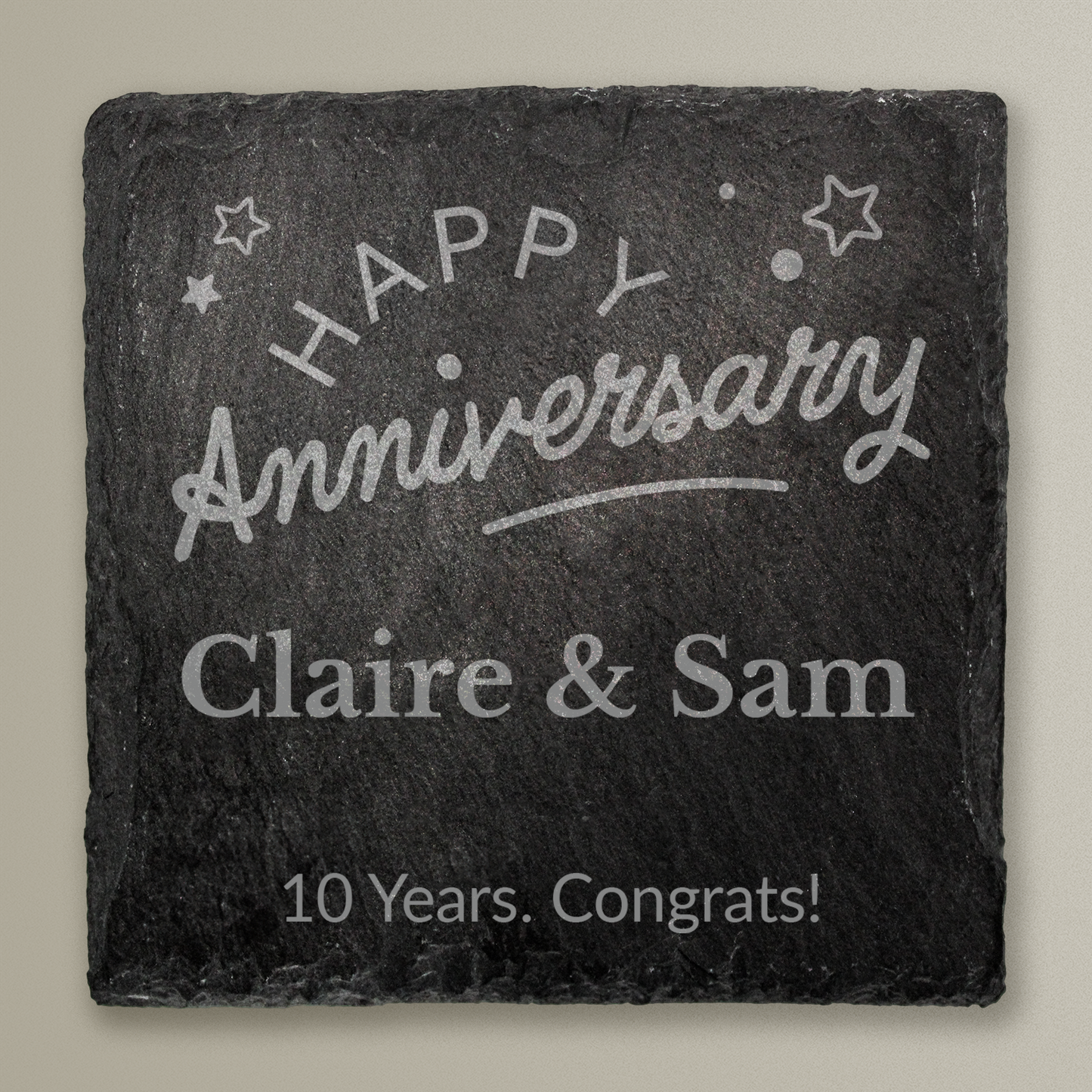 Slate coaster with 'Happy Anniversary Claire & Sam 10 Years. Congrats!' text on a gray background