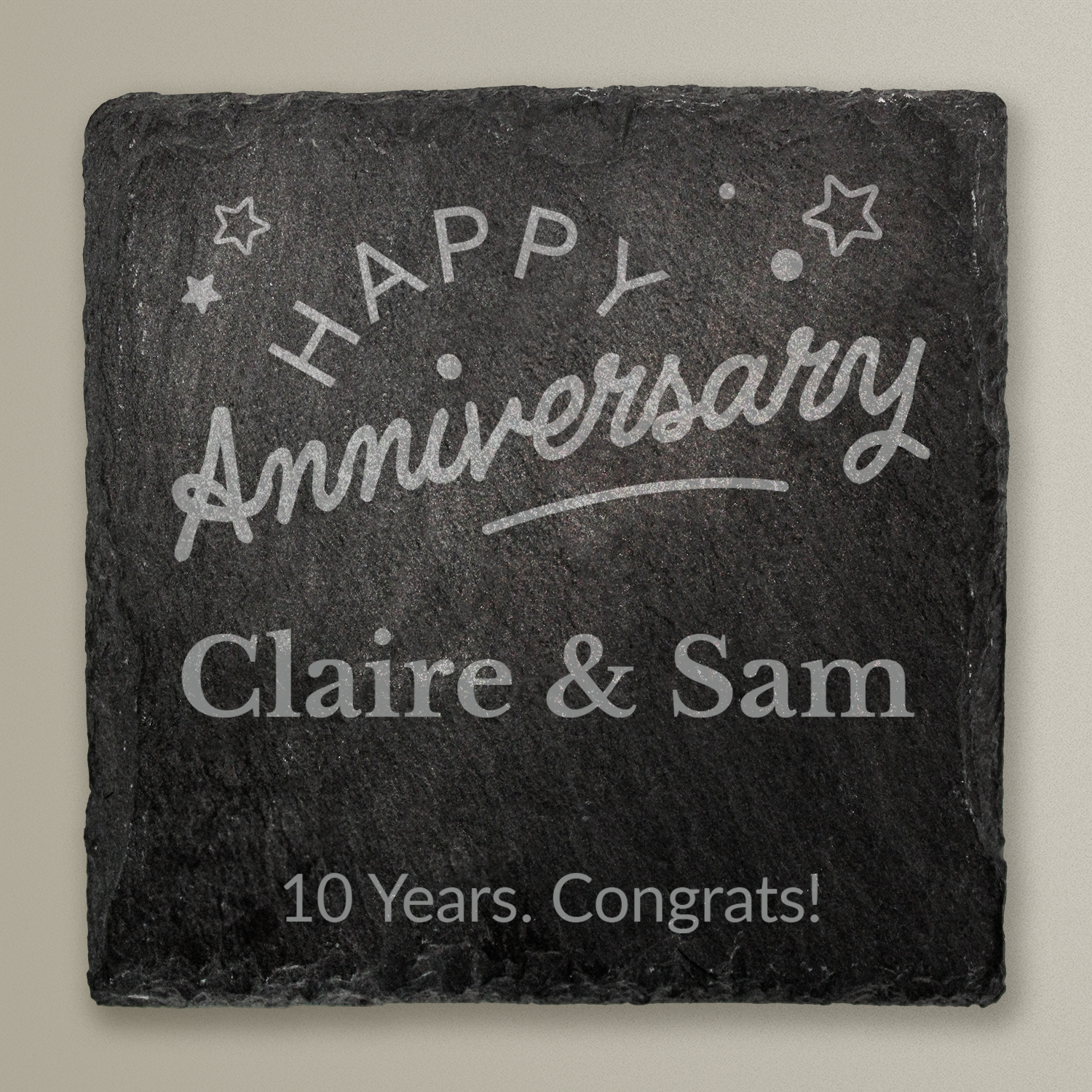 Slate coaster with 'Happy Anniversary Claire & Sam 10 Years. Congrats!' text on a gray background