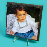 Portrait of a child on a slate plaque with a clear stand against a teal background