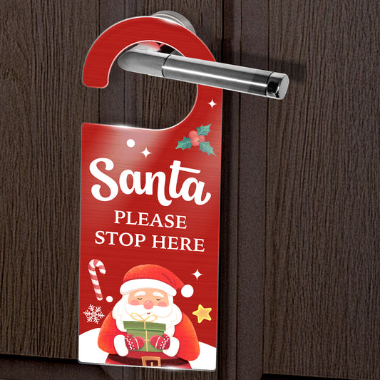 Door hanger with Santa Claus design and text 'Santa Please Stop Here' on a wooden door.