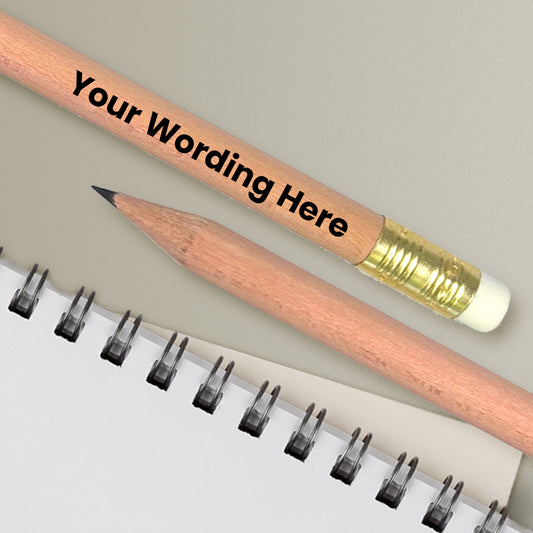 Personalized pencil with wooden body and gold ferrule on a notebook page.